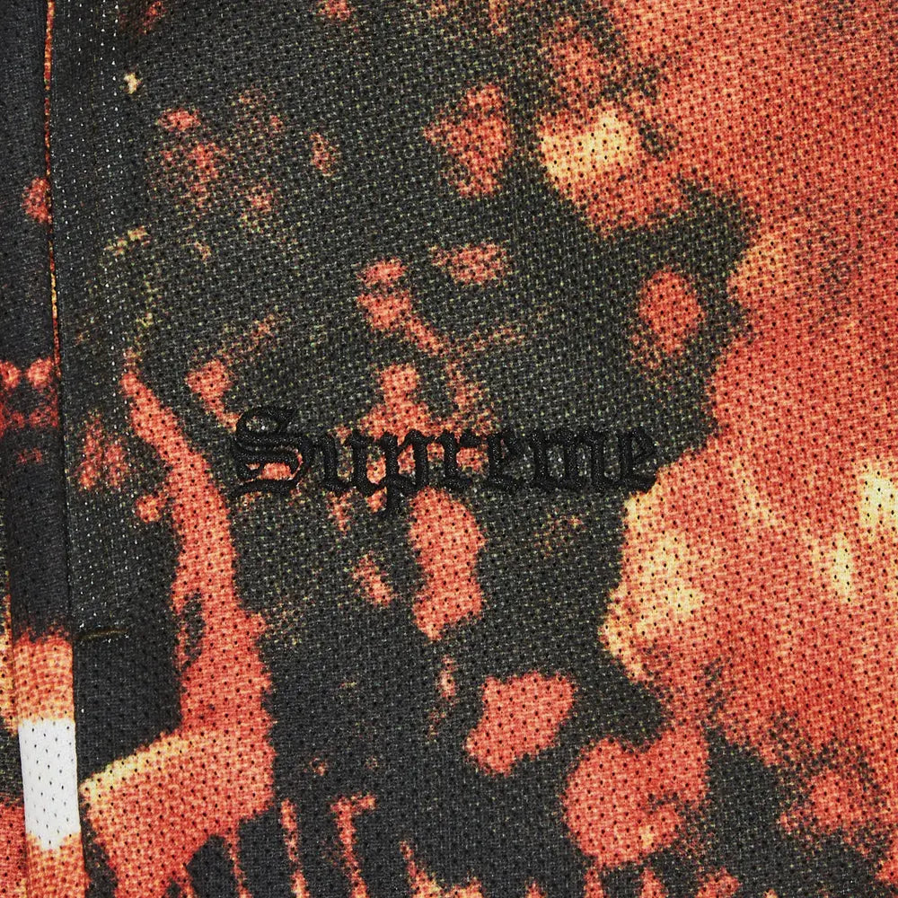 Textured fabric with a pattern and 'Supreme' branding.